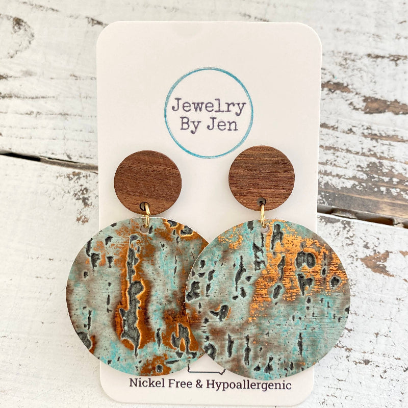 Wooden earrings with copper and green patina on a 'Jewelry By Jen' card.