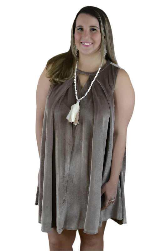 A mocha-colored, velvet, sleeveless swing dress with a keyhole front feature, showcased on a model. The dress is accompanied by a beaded necklace.